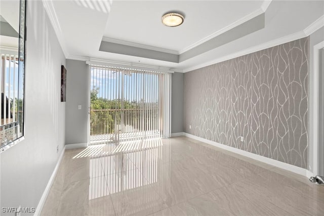 unfurnished room featuring a raised ceiling and ornamental molding