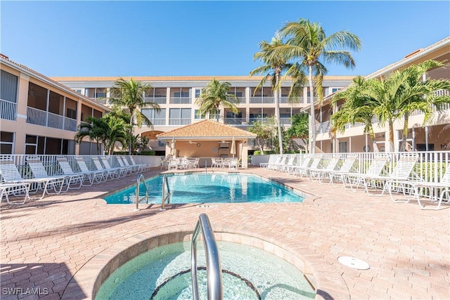 view of pool with a community hot tub and a patio area