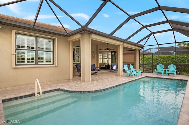 view of pool featuring glass enclosure, ceiling fan, and a patio