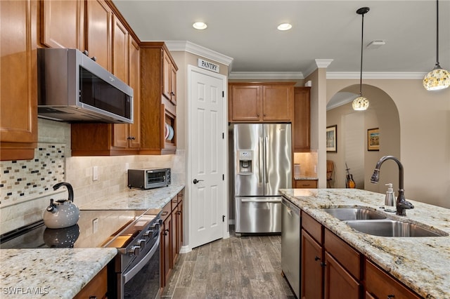 kitchen with pendant lighting, dark wood-type flooring, sink, decorative backsplash, and appliances with stainless steel finishes