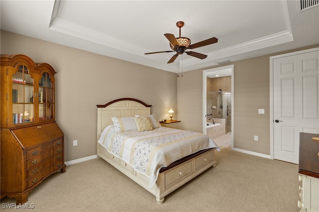 bedroom with ensuite bathroom, ceiling fan, light colored carpet, and a tray ceiling