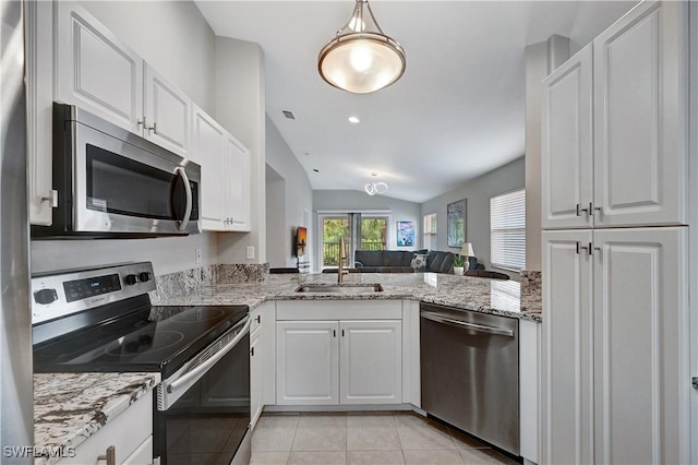 kitchen featuring lofted ceiling, white cabinets, sink, light tile patterned floors, and appliances with stainless steel finishes