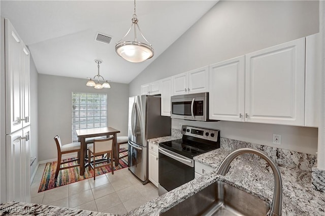 kitchen featuring white cabinetry, light tile patterned flooring, decorative light fixtures, and appliances with stainless steel finishes