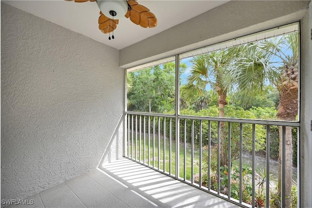 unfurnished sunroom with ceiling fan