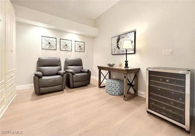 living area featuring beverage cooler and light wood-type flooring