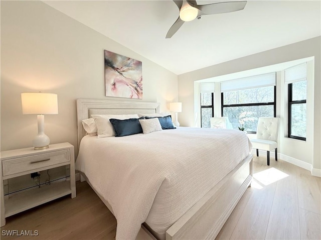 bedroom featuring hardwood / wood-style floors, ceiling fan, and lofted ceiling