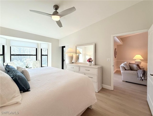 bedroom with ceiling fan, lofted ceiling, and light wood-type flooring