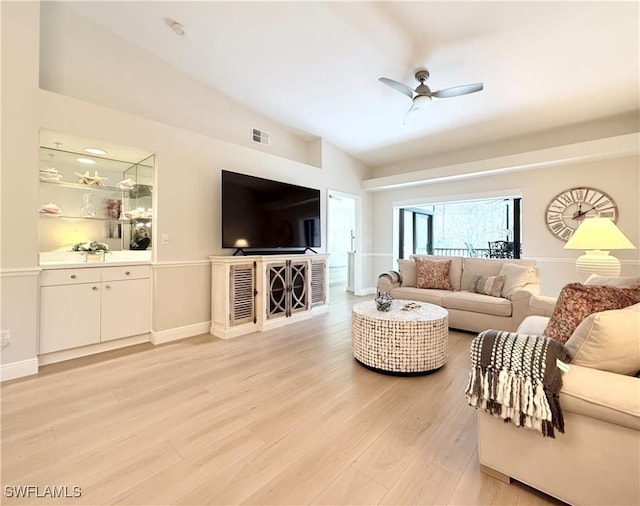 living room featuring ceiling fan, vaulted ceiling, and light wood-type flooring