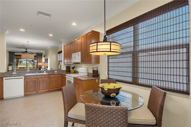 kitchen featuring kitchen peninsula, white appliances, decorative light fixtures, ornamental molding, and sink