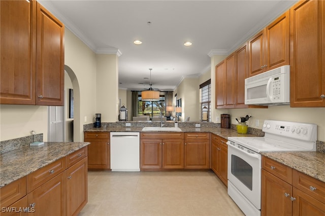 kitchen featuring decorative light fixtures, white appliances, stone counters, crown molding, and sink