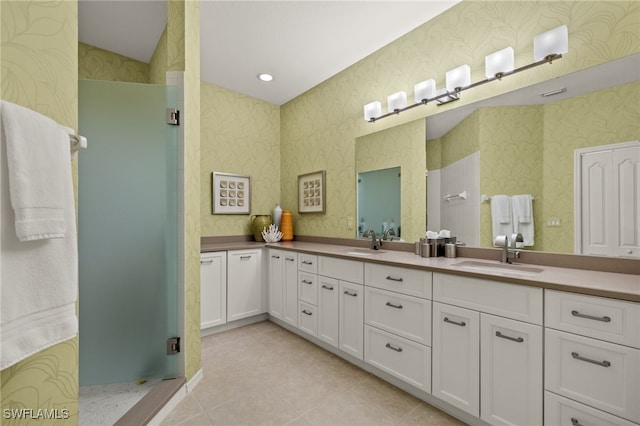 bathroom with a shower with shower door, vanity, and tile patterned flooring