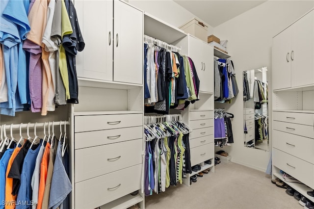 walk in closet featuring light carpet