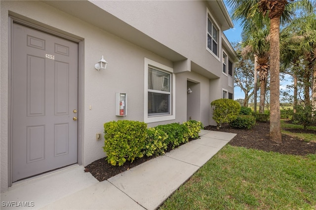 property entrance with a lawn