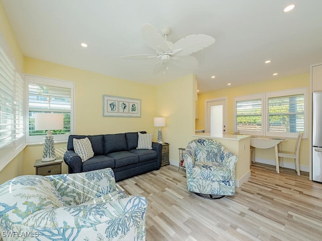 living room featuring light hardwood / wood-style flooring and ceiling fan