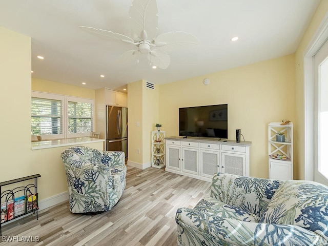 living room featuring light hardwood / wood-style flooring and ceiling fan