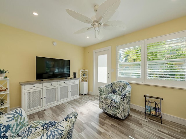 living room with light hardwood / wood-style floors and ceiling fan