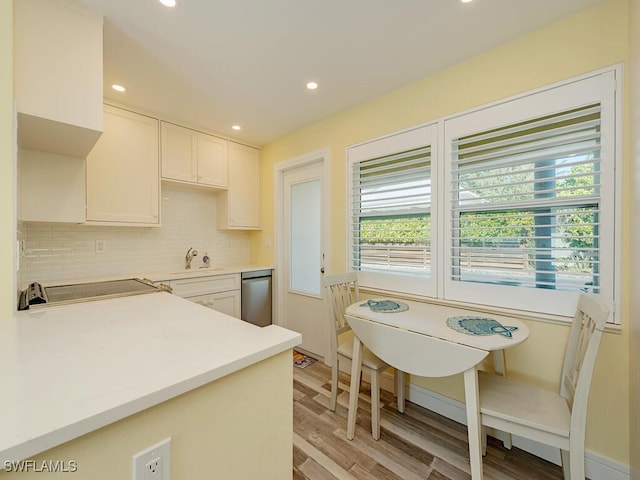 kitchen featuring a wealth of natural light, white cabinetry, sink, and stainless steel dishwasher