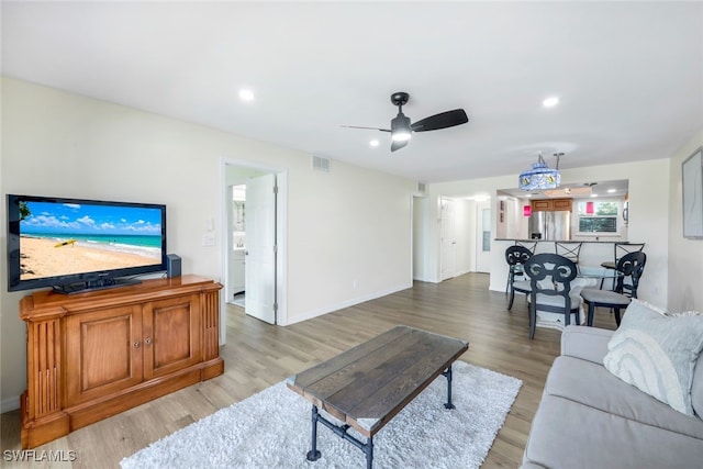 living room featuring light hardwood / wood-style floors and ceiling fan