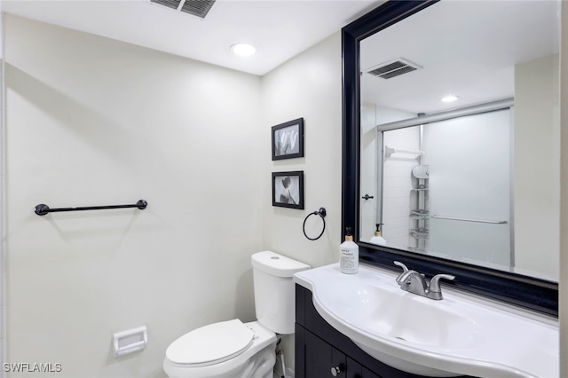 bathroom with vanity, an enclosed shower, and toilet