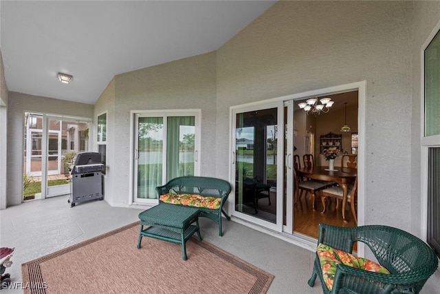 sunroom / solarium featuring plenty of natural light, a chandelier, and vaulted ceiling