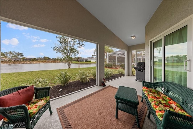 sunroom / solarium with a water view and vaulted ceiling