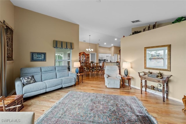 living room featuring a notable chandelier and light hardwood / wood-style flooring