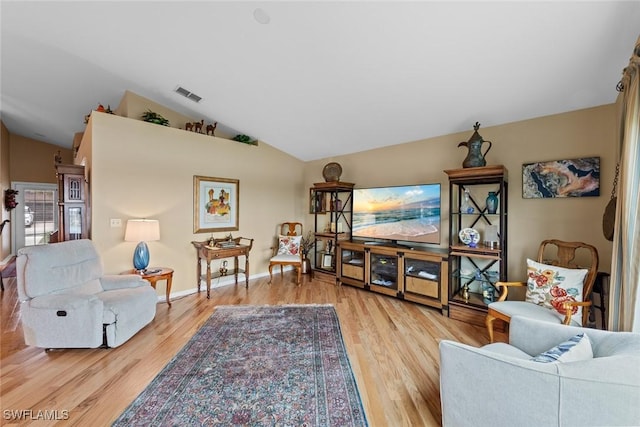 living room with light hardwood / wood-style floors and lofted ceiling