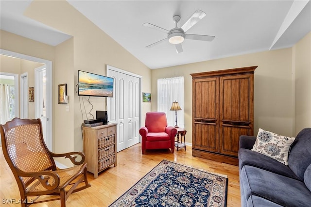 living room featuring light wood-type flooring, vaulted ceiling, and ceiling fan