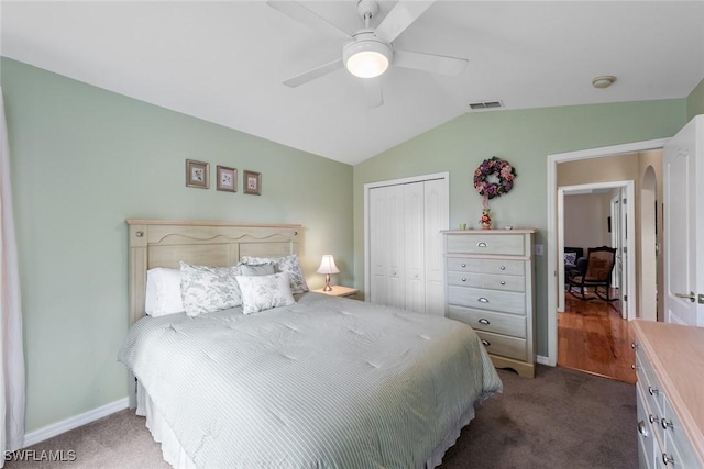 bedroom with ceiling fan, a closet, lofted ceiling, and dark colored carpet