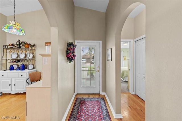 doorway featuring a high ceiling and light hardwood / wood-style floors