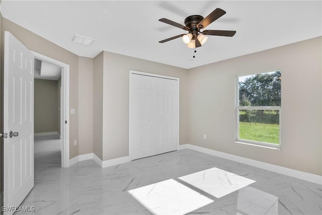 unfurnished bedroom featuring ceiling fan and a closet