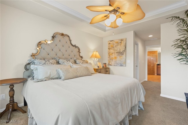 carpeted bedroom featuring ensuite bath, a raised ceiling, ceiling fan, and crown molding