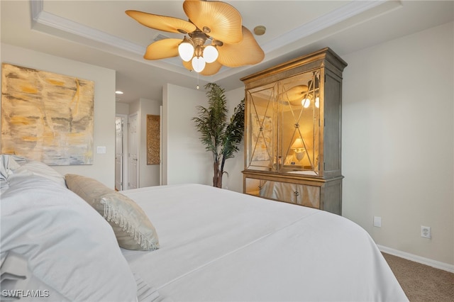 bedroom with a tray ceiling, ceiling fan, crown molding, and carpet