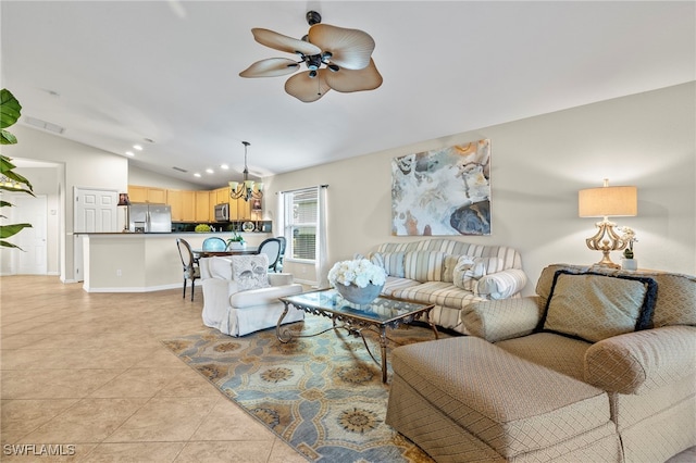 living room with ceiling fan with notable chandelier, lofted ceiling, and light tile patterned flooring