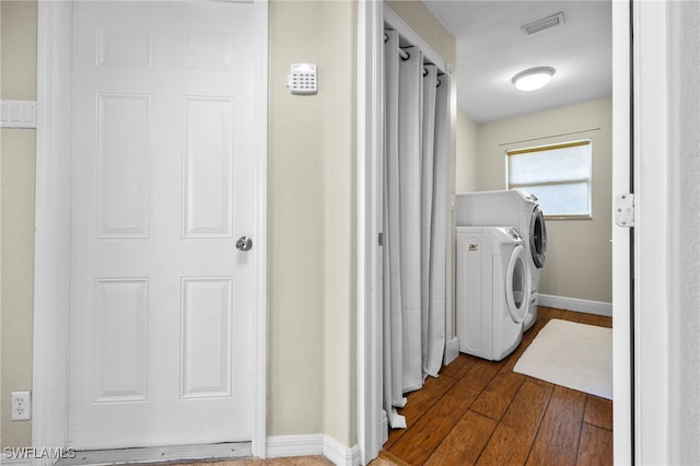 laundry area featuring dark wood-type flooring and washing machine and clothes dryer