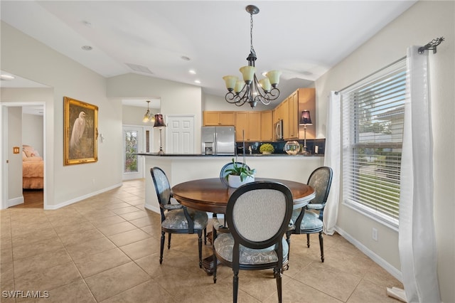 tiled dining space featuring an inviting chandelier and vaulted ceiling