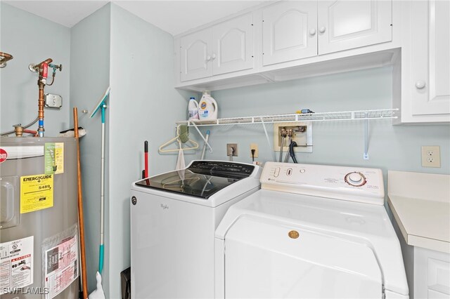 laundry room with washer and clothes dryer, cabinets, and water heater