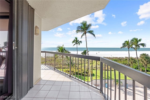 balcony featuring a water view and a beach view