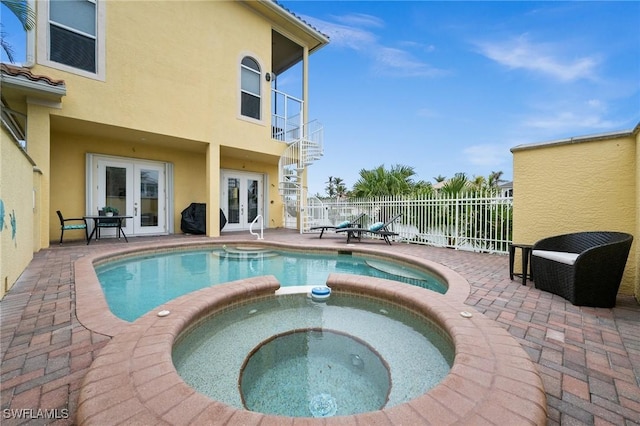 view of pool with an in ground hot tub, french doors, and a patio