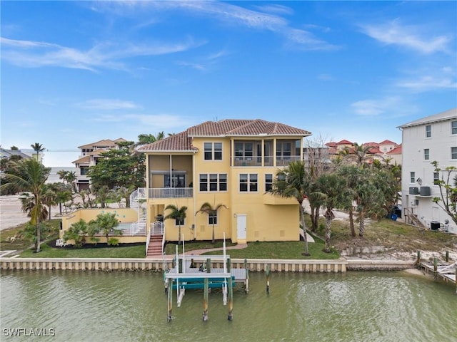 rear view of house featuring a balcony, a water view, and a sunroom