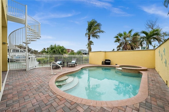 view of swimming pool featuring an in ground hot tub and a patio