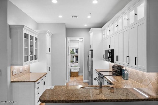 kitchen featuring white cabinets, appliances with stainless steel finishes, and kitchen peninsula