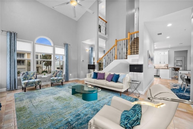 tiled living room featuring ceiling fan, a high ceiling, and sink