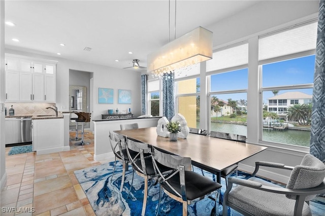 tiled dining room featuring a water view