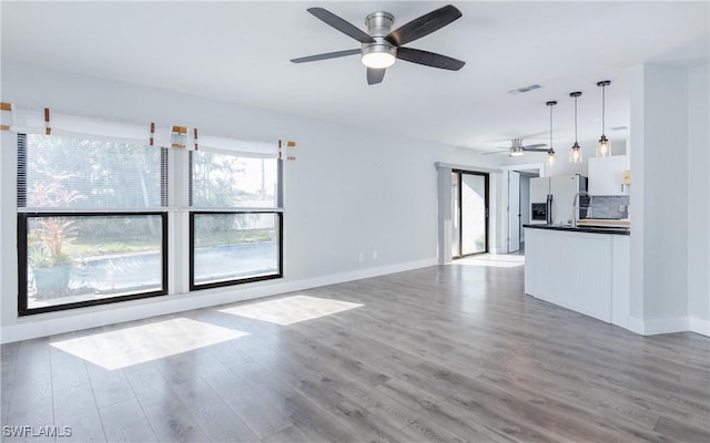 unfurnished living room with ceiling fan and light hardwood / wood-style flooring