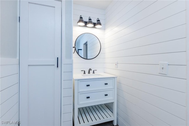 bathroom featuring wood walls and vanity