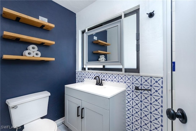 bathroom featuring vanity, toilet, and decorative backsplash