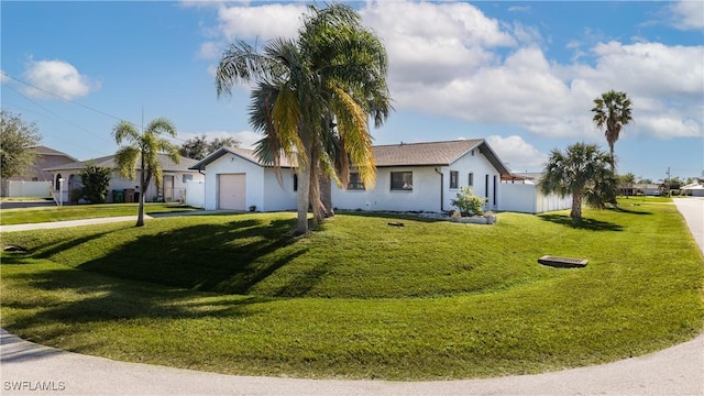 ranch-style house with a garage and a front lawn