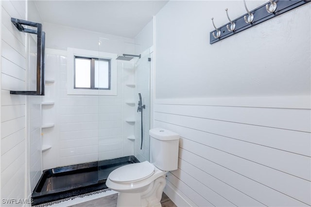 bathroom with toilet, hardwood / wood-style flooring, and tiled shower