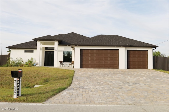 prairie-style home with a front lawn and a garage